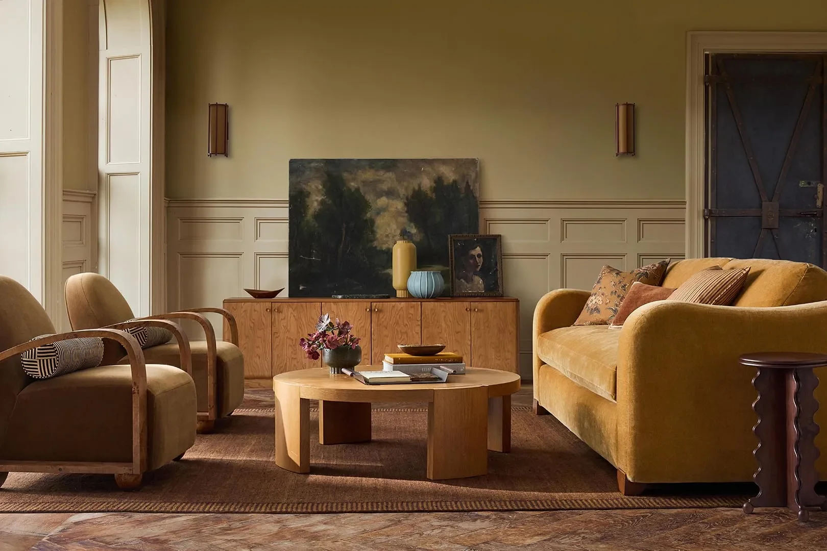 Arched Burl Arm Chair,Caged Sconce,Burl Wood Media Console,Burl Inlay Coffee Table,Scalloped Drink Table, andCameron Stripe Flatweave Wool Rug. | Courtesy of West Elm