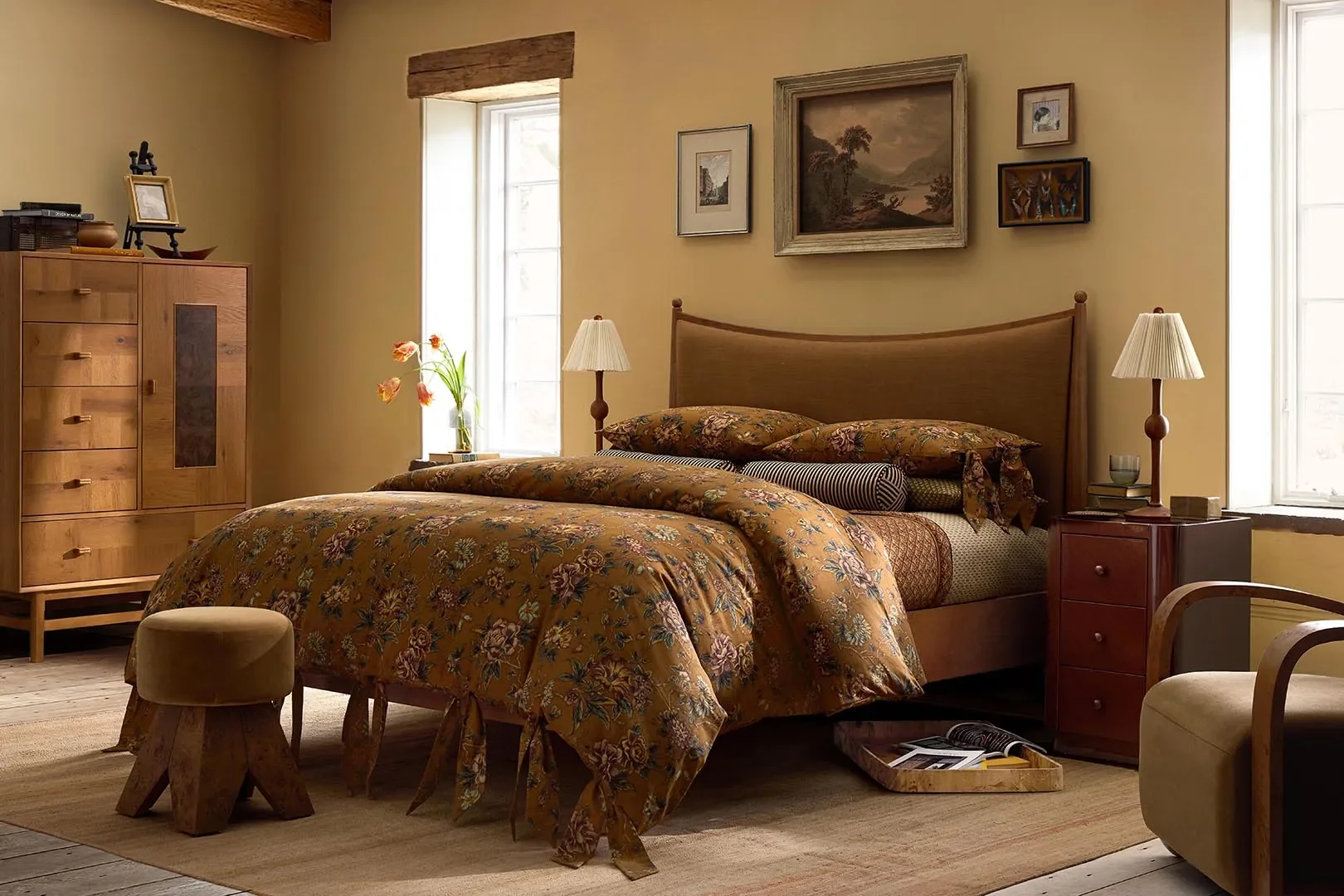 Two-Tone Chifforobe,Upholstered Curved Burl Wood Bed,Wild Garden Duvet Cover & Shams,Stripe Bolster Pillow,Ribbed Wood Table Lamp, andLacquered Nightstand. | Courtesy of West Elm