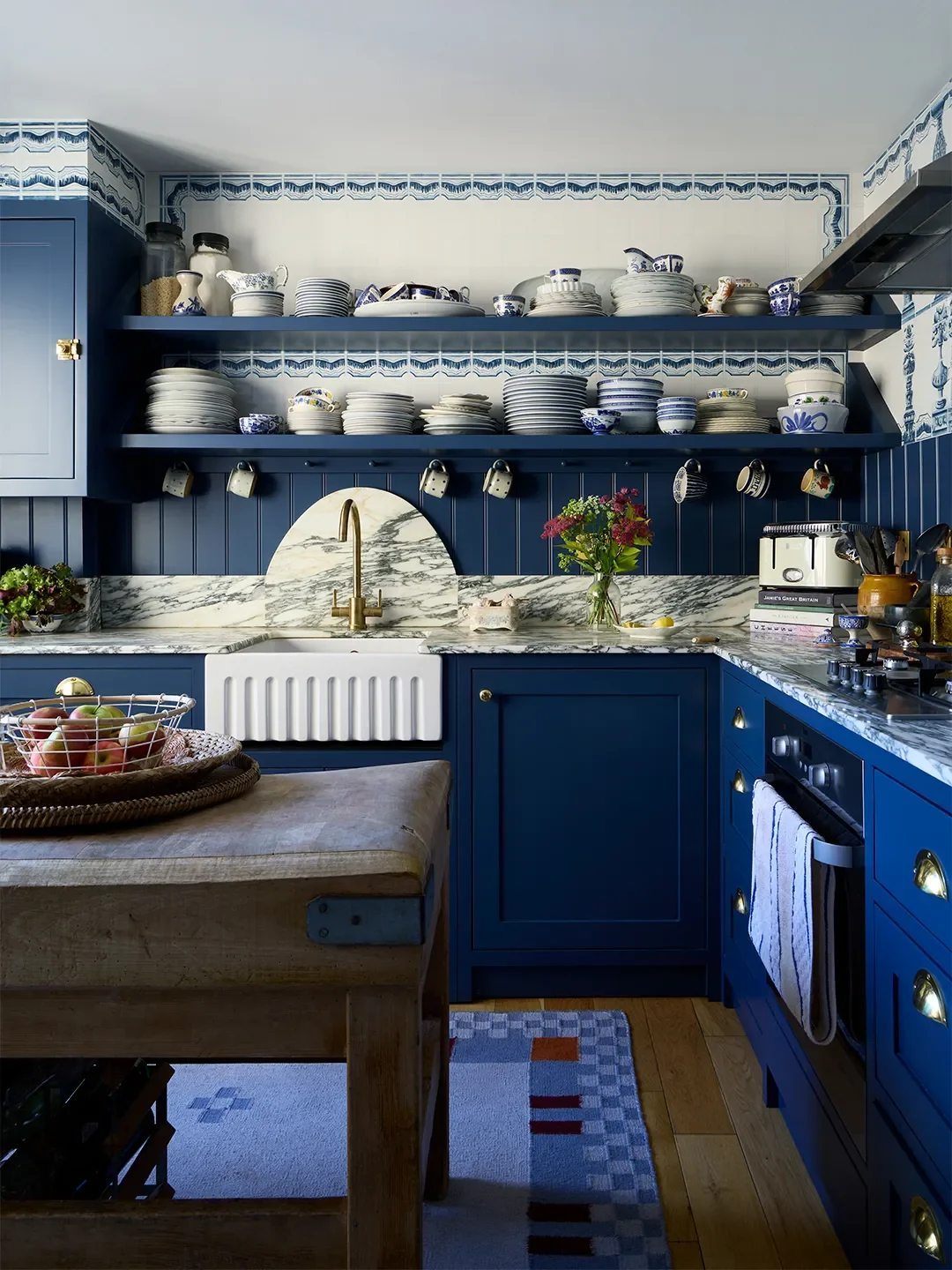 A serious shade of navy, Stiffkey Blue by Farrow & Ball, was selected once the marble had been chosen for the kitchen. Upon reveal, it was more vibrant than homeowner India Holmes had planned, but it 