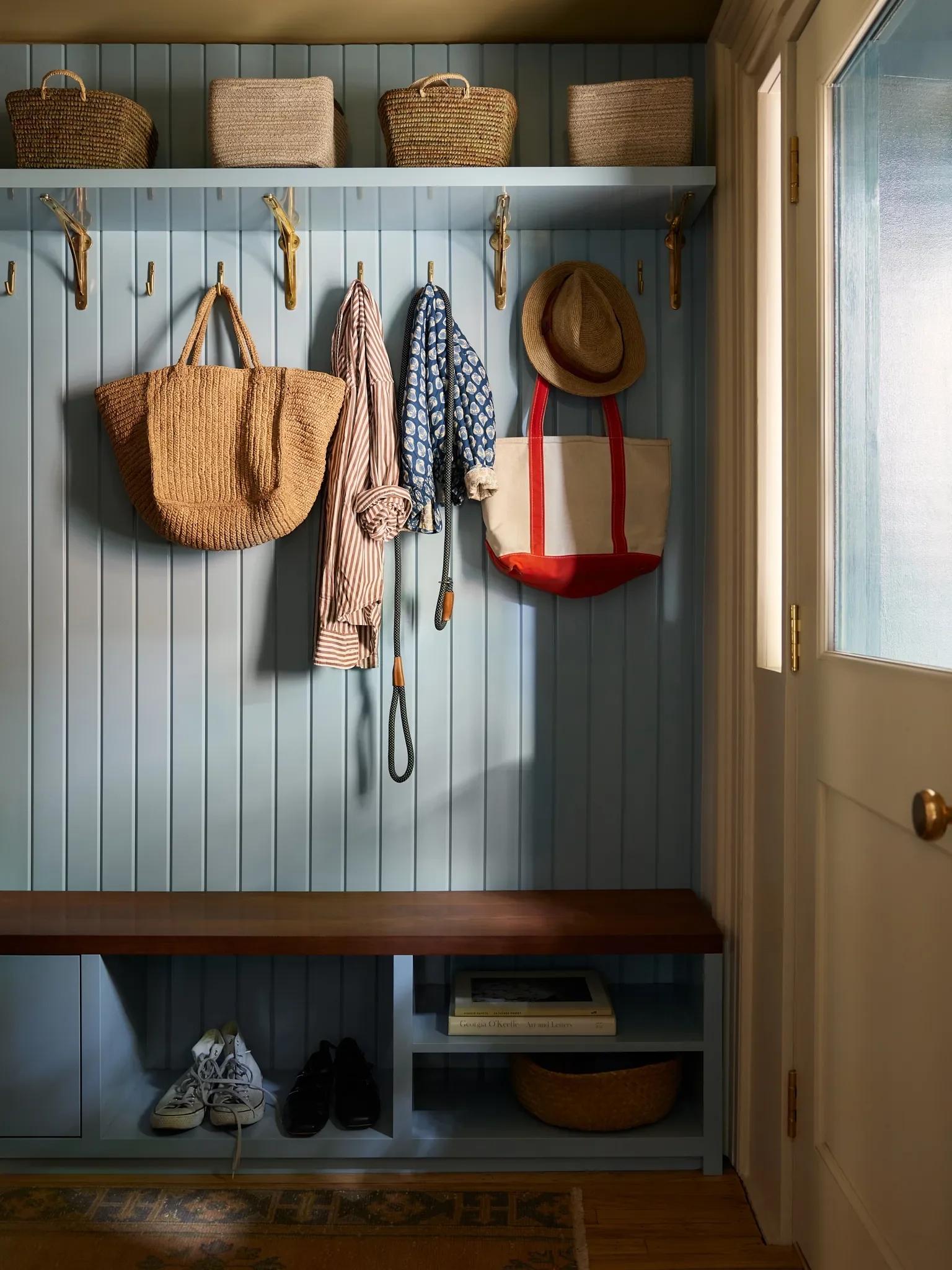 The lower level entrance opens onto a hallway with plenty of easily-accessed storage and a mahogany bench seat.