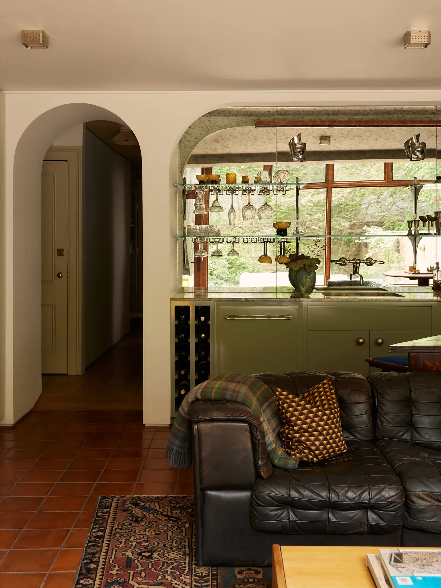 The garden level family room is chic but incredibly comfortable. A wet bar was outfitted with antique glass to reflect the light in the room and the patio area beyond.