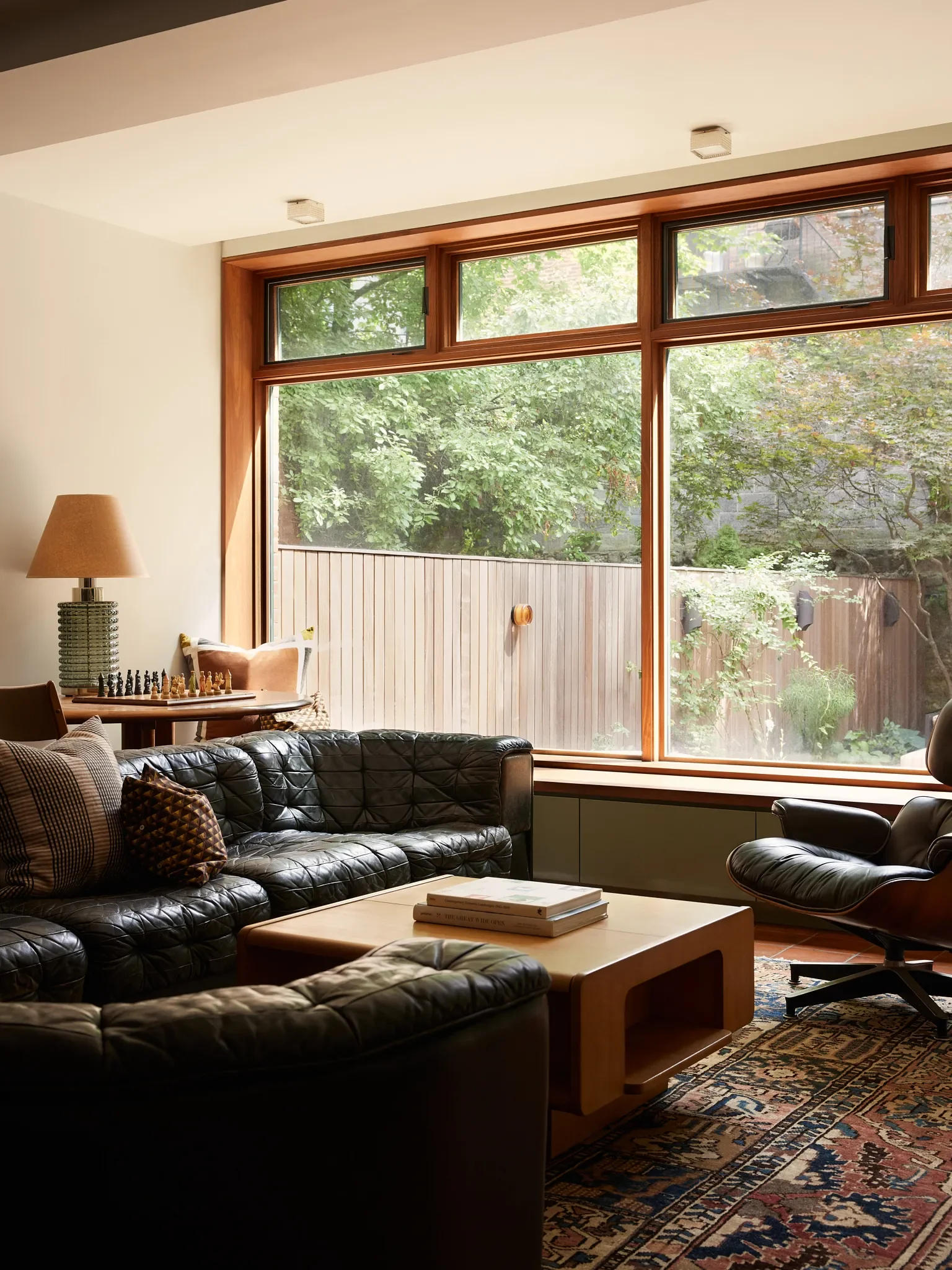 A vintage de Sede sofa gives structure to the room, along with an Eames lounger and 1960s coffee table. | Ceiling lights,Kelly Wearstler.