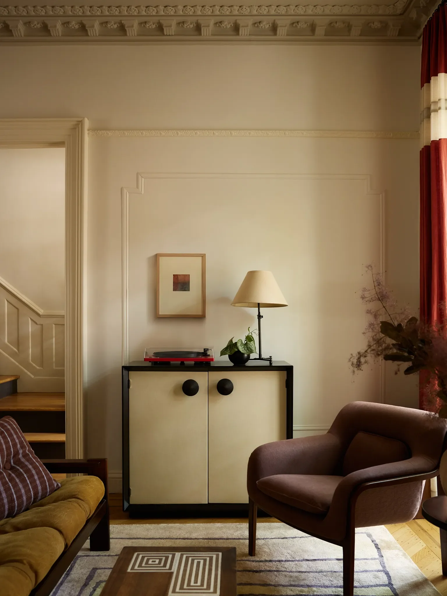 The sitting room features a midcentury mix, with Knoll lounge chairs and a Carl Straub sofa; an Art Deco cabinet was customized for record storage. | Rug,Cold Picnic.