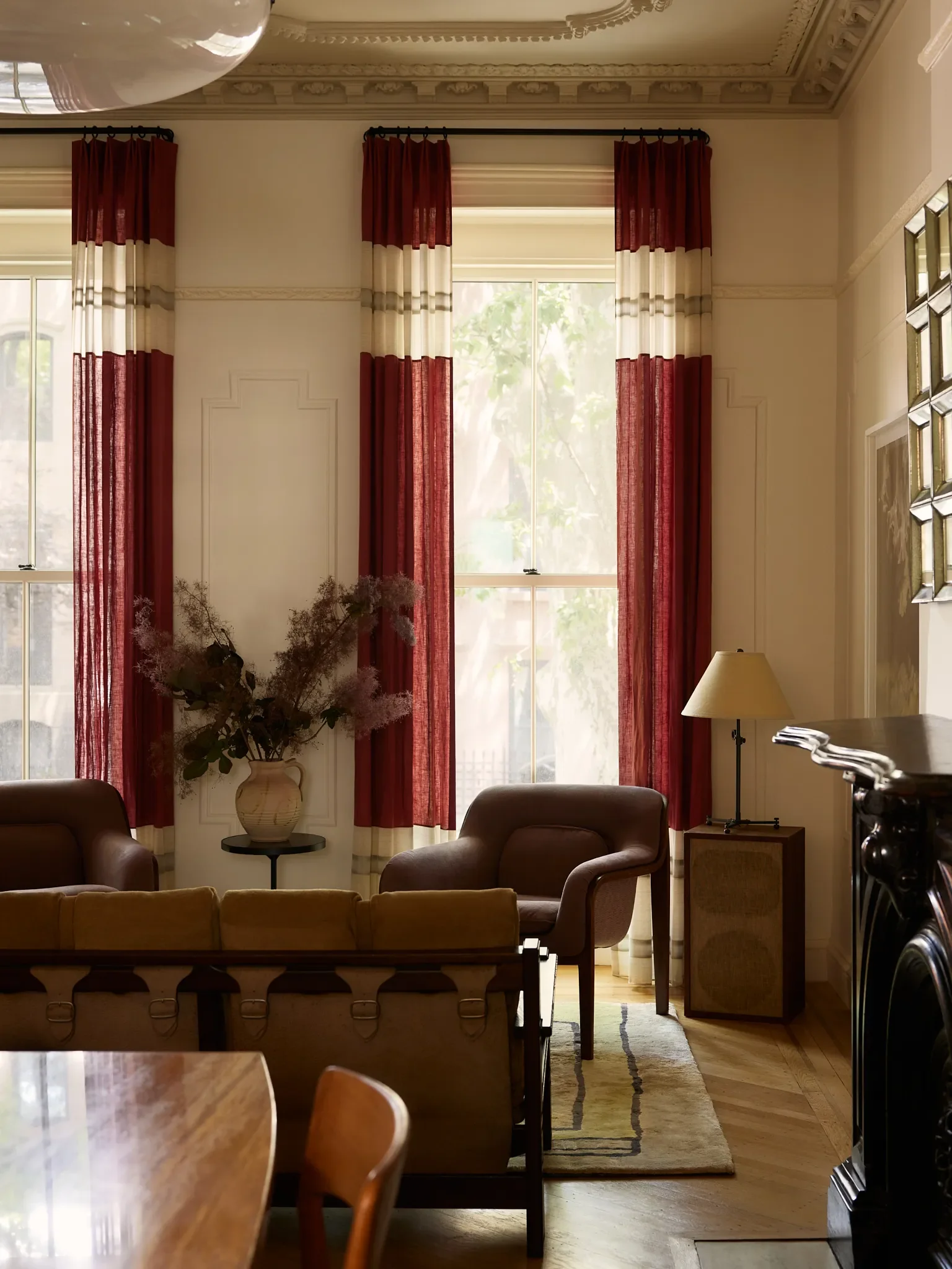 Custom drapery—a mix of textiles by Holly Hunt—emphasizes the grand scale of the parlor level. A speaker—the client’s own—serves as a kicky side table in one corner.
