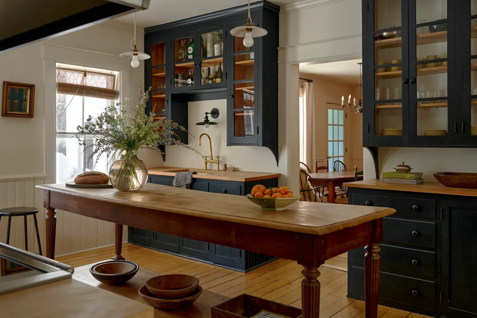 “Part of living with antiques is drawers don’t glide very well anymore and you’re wrestling with them. That’s part of the charm, not everything has to be so easy,” Johnston says. | Pendants,DeVol. Cab